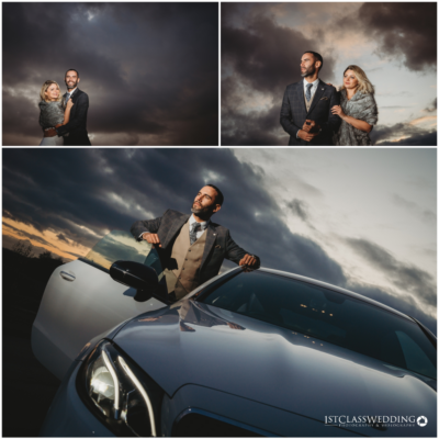 Couple with car under dramatic sunset sky.