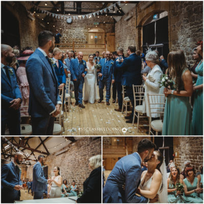 Rustic wedding ceremony in barn with joyful bride and groom