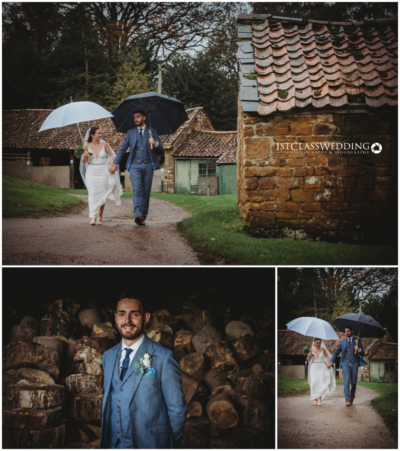 Bride and groom walking under umbrellas, rustic wedding setting.