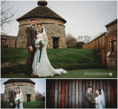 Bride and groom by historic stone building and wooden fence.