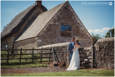 Couple with dog at rustic wedding venue.