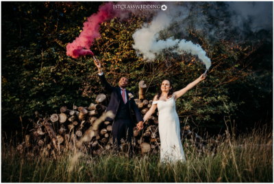 Couple with smoke flares celebrating at wedding.