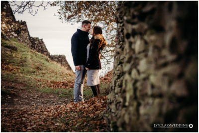 Couple embracing near historic ruins in autumn.