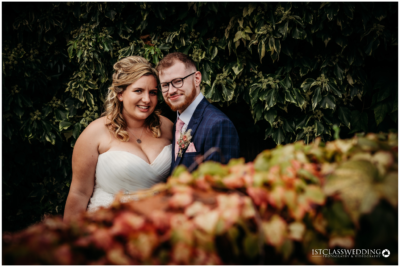 Bride and groom posing in garden foliage setting