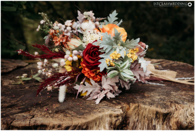 Autumnal wedding bouquet on rustic wooden surface.