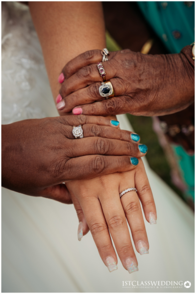 Three generations showing hands with wedding rings