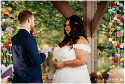Couple exchanging vows at outdoor wedding ceremony.