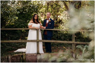 Bride and groom posing in a lush garden setting.