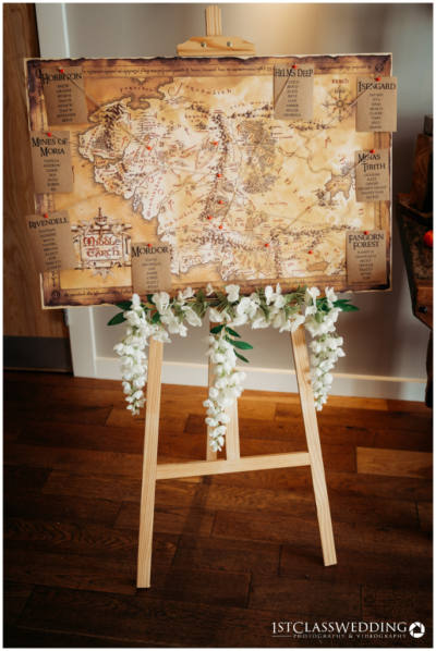 Decorative Middle-earth map on easel with white flowers.