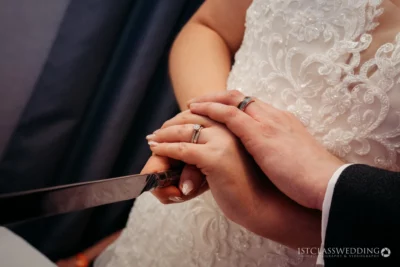 Bride and groom holding hands with wedding rings visible