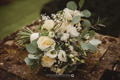Bridal bouquet with white roses and eucalyptus on stone