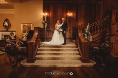 Couple at grand staircase wedding venue.