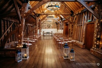Rustic barn wedding venue with wooden beams and fairy lights.