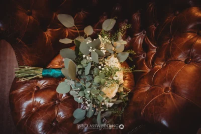 Wedding bouquet on vintage leather armchair.