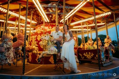 Couple on carousel at wedding celebration.