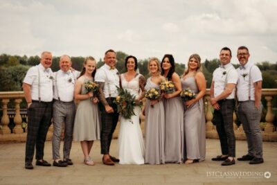 Wedding party posing on balcony with bouquets.
