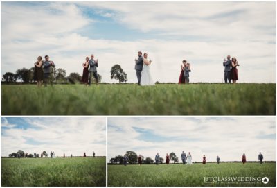 Wedding party posing in a field, playful and joyful.