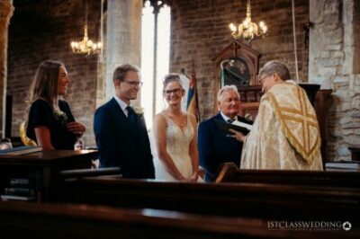 Wedding ceremony in a church with smiling bride and groom.