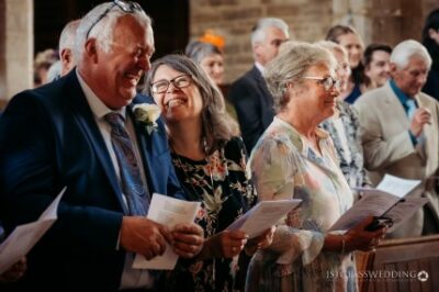 Joyful guests laughing at wedding ceremony.