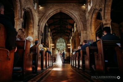 Wedding ceremony in historic church aisle