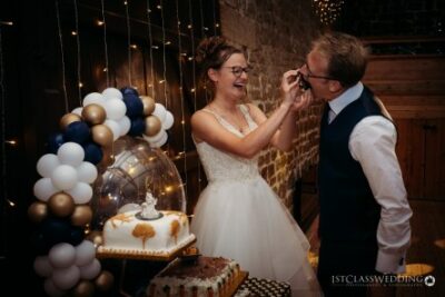 Joyful bride and groom enjoying wedding cake cutting.