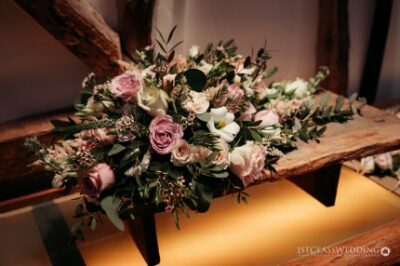 Elegant wedding bouquet on rustic wooden bench.