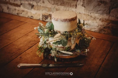 Rustic wedding cake with floral decoration on wooden table.