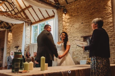 Couple exchanging vows at rustic wedding venue.