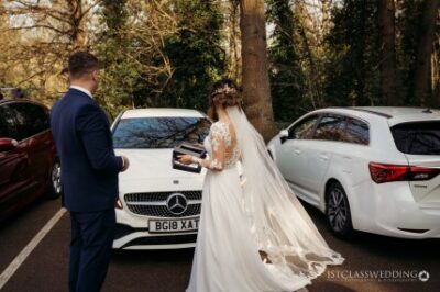 Bride and groom with car at wedding ceremony.