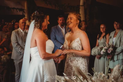 Two brides laughing at wedding ceremony.