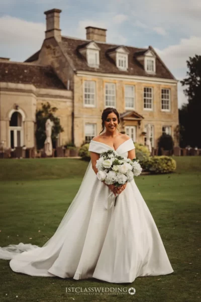 Bride with bouquet at manor house wedding.