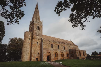 Historic stone church with spire in rural UK.