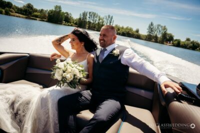 Bride and groom enjoying boat ride on sunny day.