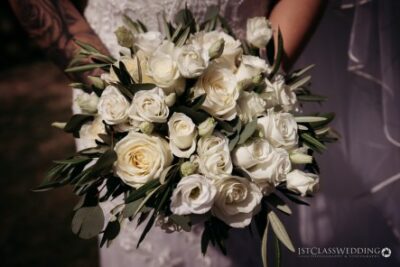 Bride holding white rose wedding bouquet