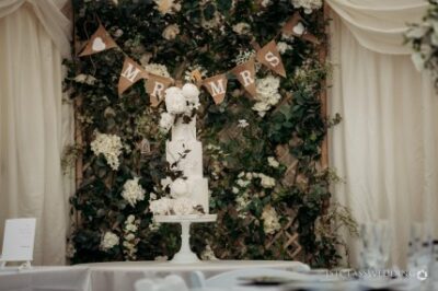 Elegant wedding cake under 'Mr & Mrs' bunting and greenery.
