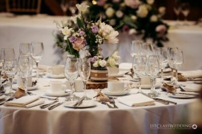 Elegant wedding table setting with floral centerpiece.
