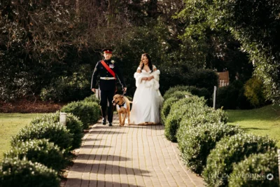 Bride and groom with dog at garden wedding.