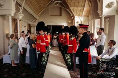 Bride walking down aisle with guardsmen in UK wedding.