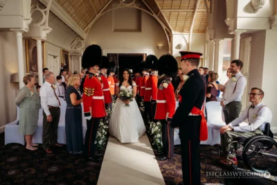 Bride walking through guards of honour at wedding.