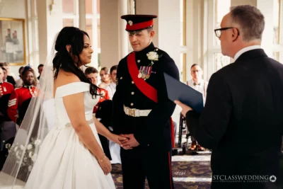 Military groom and bride exchanging vows at wedding.