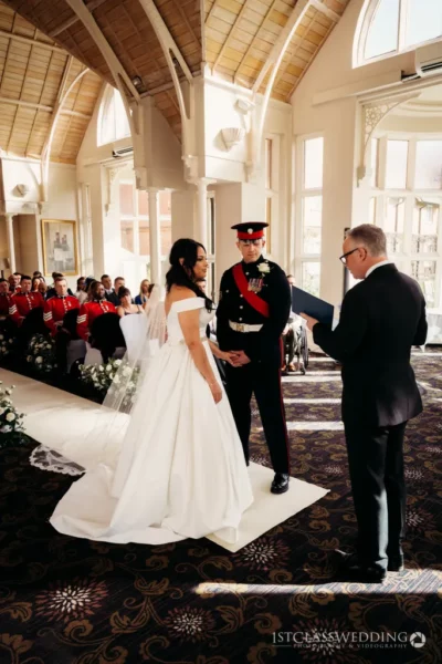 Wedding ceremony in elegant hall with bride, groom, and officiant.