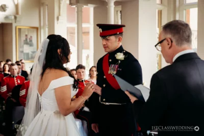 Bride and groom exchanging rings at military wedding.