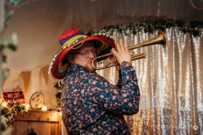 Man playing trumpet wearing sombrero at festive event.