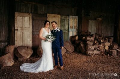 Bride and groom posing in rustic barn setting