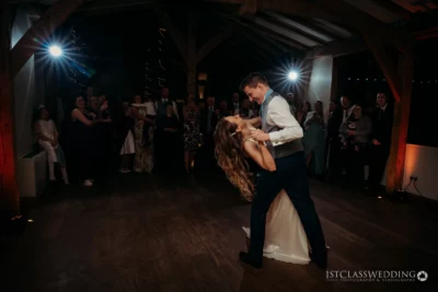 Couple's first dance at wedding with guests watching.