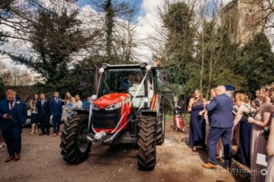 Wedding guests admiring couple on tractor.