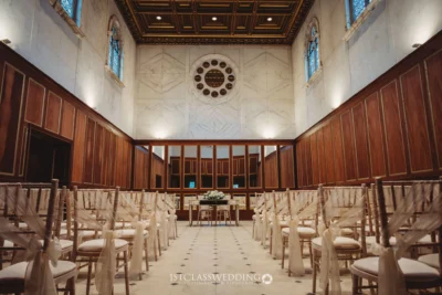 Elegant wedding ceremony hall interior with chairs and decor.