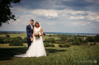 Bride and groom posing in sunny countryside field