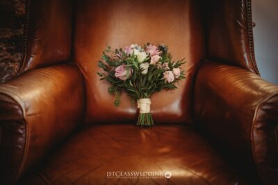 Bridal bouquet on vintage leather armchair.
