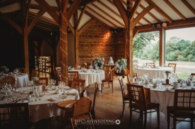 Elegant barn wedding reception setup with tables.